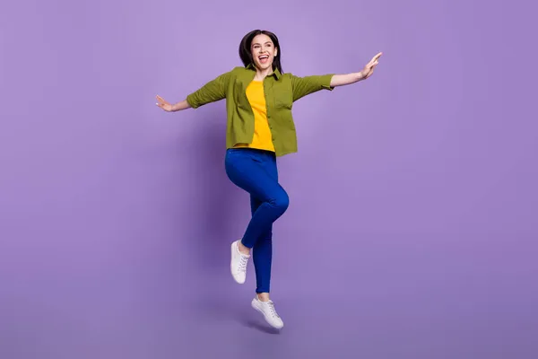Full längd foto av ung glad flicka glad positiv leende bekymmerslös hoppa isolerad över violett färg bakgrund — Stockfoto