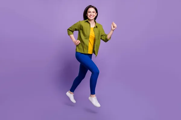 Longitud completa perfil lado de la foto de la joven feliz sonrisa positiva saltar ir correr prisa aislado sobre fondo de color violeta —  Fotos de Stock