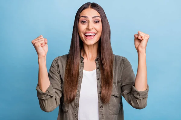 Foto portret brunette vrouw gebaren als winnaar glimlachen geïsoleerde pastel blauw kleur achtergrond — Stockfoto