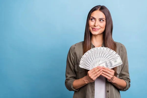 Foto ritratto bruna donna cerca copyspace mantenendo dollari isolato pastello sfondo di colore blu — Foto Stock