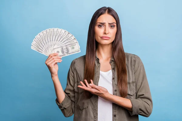 Foto ritratto bruna donna scontroso mantenere dollari pila isolato pastello colore blu sfondo — Foto Stock