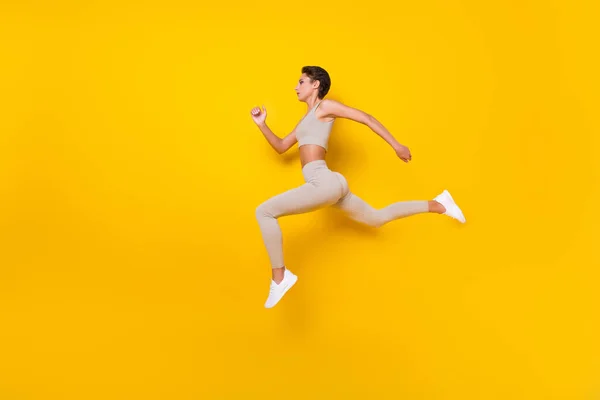 Longitud completa tamaño del cuerpo perfil vista lateral de la chica bonita saltar corriendo pérdida de peso aislado sobre fondo de color amarillo brillante — Foto de Stock