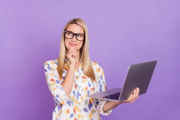 Foto di smart sognante giovane donna indossare occhiali camicia di stampa braccio sorridente mento tenendo dispositivo moderno isolato colore viola sfondo — Foto Stock