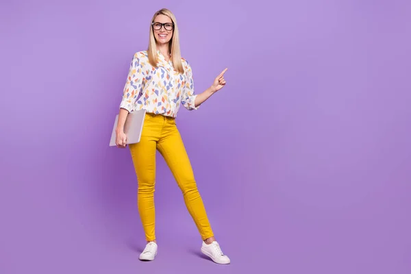 Φωτογραφία από γλυκό χαριτωμένο ώριμη κυρία ντυμένος γυαλιά εκτύπωσης μπλούζα κρατώντας σύγχρονο gadget δείχνοντας κενό χώρο απομονωμένο πορφυρό φόντο χρώμα — Φωτογραφία Αρχείου