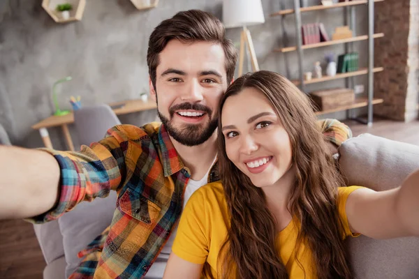 Foto do blogueiro influenciador casal tirar selfie sorriso do dente usar roupas casuais sentar sofá em casa dentro de casa — Fotografia de Stock