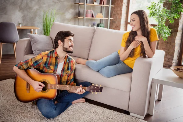 Foto av glad man spela gitarr serenad melodi flickvän lyssna bära casual kläder sitta soffa hemma — Stockfoto