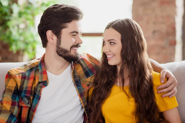 Photo of cheerful tender couple embrace each other toothy smile wear casual clothes sit couch home indoors — Stock Photo, Image