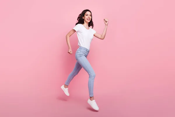 Foto de comprimento total de alegre jovem mulher bonita saltar para cima correr venda espaço vazio isolado no fundo cor-de-rosa — Fotografia de Stock