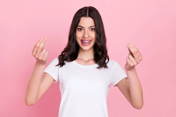 Foto di positivo giovane donna allegra felice fanno segno di soldi dita isolato su sfondo di colore rosa pastello — Foto Stock