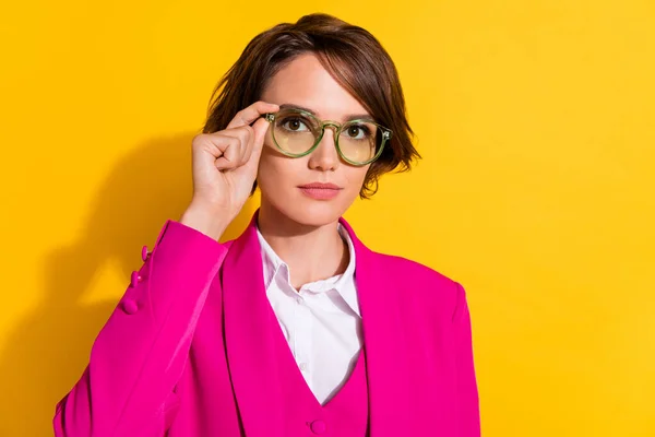 Foto de bonito sério jovem mulher vestido rosa terno braço óculos isolado cor amarela fundo — Fotografia de Stock