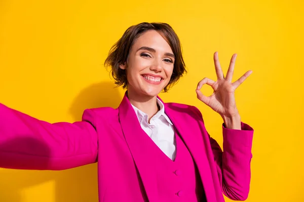 Zelfportret van aantrekkelijke vrolijke meisje tonen ok-teken advertentie advertentie geïsoleerd over helder gele kleur achtergrond — Stockfoto