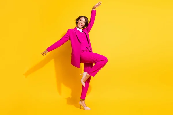 Foto de adorável bonito jovem senhora desgaste rosa terno sorrindo dançando isolado cor amarela fundo — Fotografia de Stock