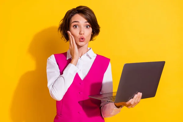Fotografie docela dojem mladá žena oblečená růžová oblek drží moderní gadget rameno tvář izolované žluté pozadí — Stock fotografie