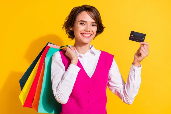 Portré vonzó vidám lány gazdaság táskák bankkártya rendelés új ruhák ajándékok elszigetelt felett élénk sárga színű háttér — Stock Fotó