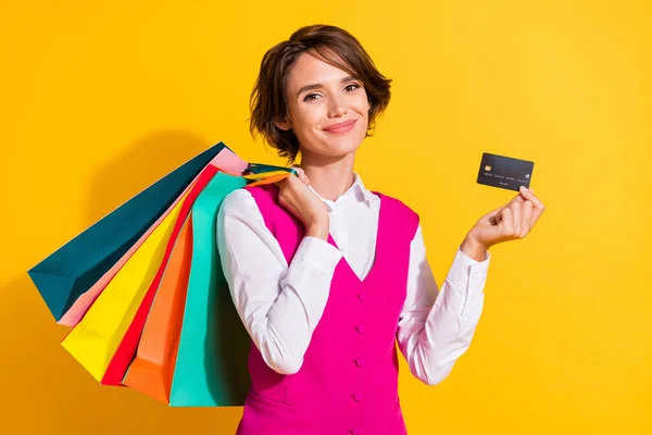 照片中甜美有趣的年轻女子身穿粉色西服，手握购物者信用卡，微笑着与外界隔绝的黄色背景 — 图库照片