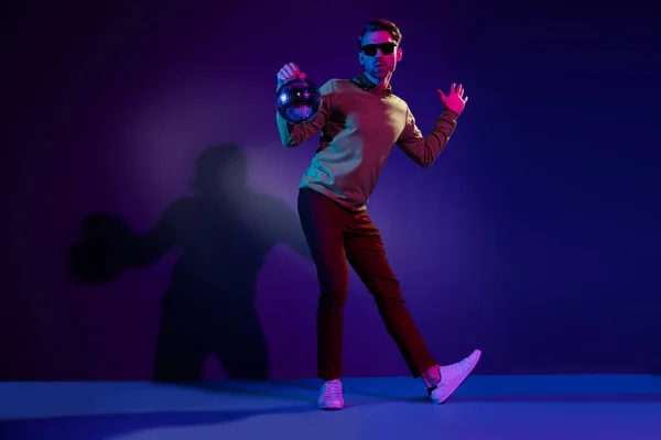 Full längd foto av charmiga unga positiva man hålla hand disco boll dans isolerad på neon bakgrund — Stockfoto