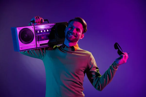 Foto de hombre joven feliz sonrisa positiva mantenga boombox audio de música retro aislado sobre fondo de color neón — Foto de Stock
