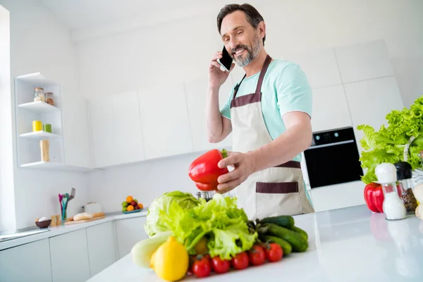 Mavi tişörtlü, yakışıklı, yakışıklı bir adamın yemek pişirirken modern aletlerden bahsederken çekilmiş bir fotoğraf. — Stok fotoğraf