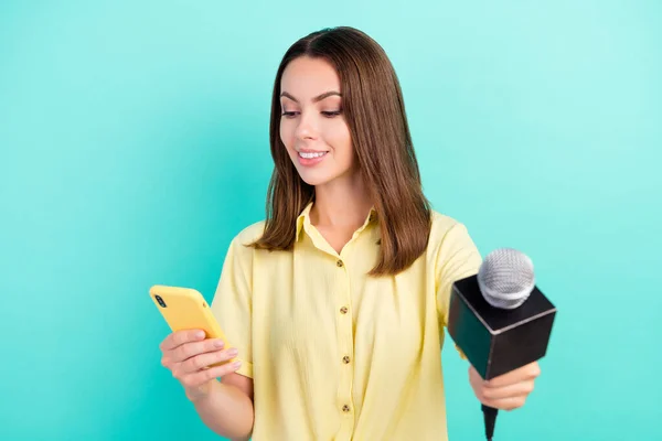 Foto van funky jonge brunette dame nemen interview kijken telefoon dragen geel top geïsoleerd op teal kleur achtergrond — Stockfoto