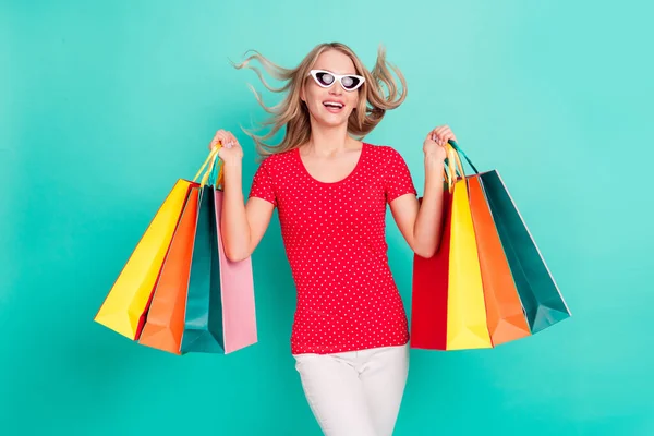 Photo de jeune femme heureux sourire positif tenir sacs à provisions noir vendredi isolé sur fond de couleur turquoise — Photo