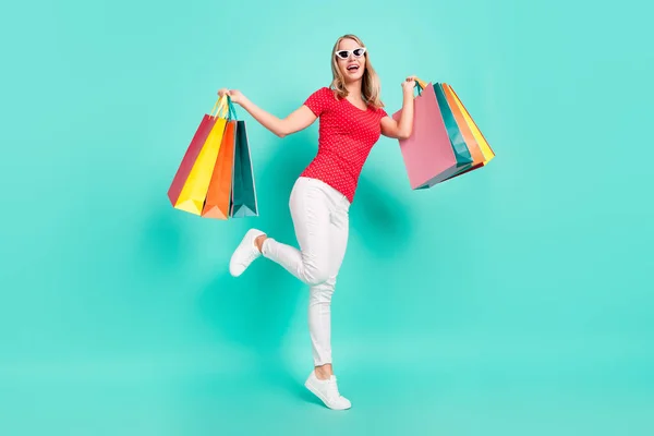 Full length profile side photo of young woman happy θετικό χαμόγελο ενθουσιασμένοι τσάντες πώλησης κατάστημα απομονωμένο πάνω από τυρκουάζ φόντο χρώμα — Φωτογραφία Αρχείου