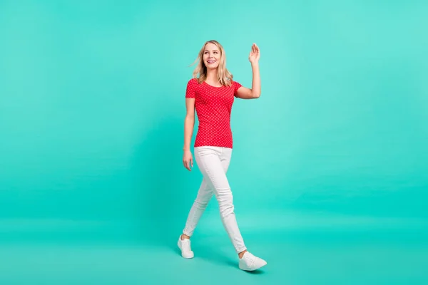 Perfil de cuerpo completo lado de la foto de la joven sonrisa positiva feliz ir caminando saludar la mano aislado sobre fondo de color verde azulado — Foto de Stock