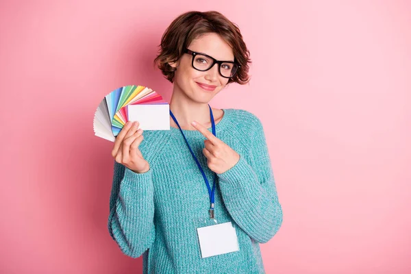 Foto de lady hold card fan dedo directo blanco vacío espacio usar gafas insignia azul suéter aislado rosa fondo —  Fotos de Stock