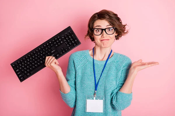 Foto di triste riccio bruna acconciatura signora tenere gli occhiali tastiera blu maglione isolato su sfondo di colore rosa — Foto Stock