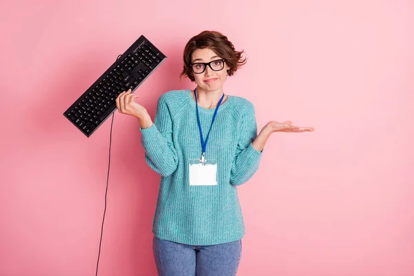 Zdjęcie nieświadomej młoda dama trzymać keyboard programista nosić identyfikator izolowane na różowy kolor tła — Zdjęcie stockowe
