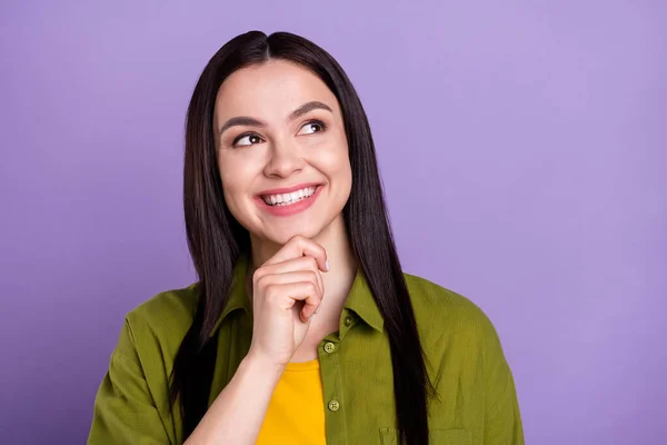 Foto di affascinante sognante giovane signora vestita di verde abiti sorridente braccio mento cercando spazio vuoto isolato colore viola sfondo — Foto Stock