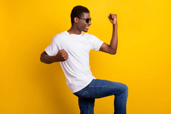 Foto av positiva afro amerikan ung man höja nävar vinnare bära glasögon isolerade på gul färg bakgrund — Stockfoto