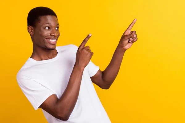 Foto van vrolijke jonge Afro-Amerikaanse man kijken punt vinger lege ruimte glimlach geïsoleerd op gele kleur achtergrond — Stockfoto