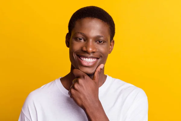 Foto van jonge gelukkig donkere huid man houden hand kin goed humeur glimlach denken geïsoleerd op gele kleur achtergrond — Stockfoto