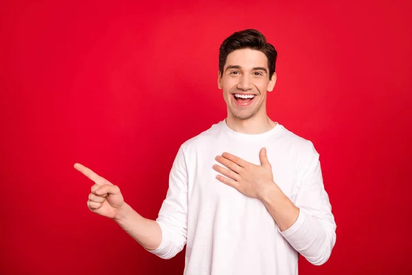 Foto portret brunet man in wit shirt lachen wijzende vingers lege ruimte lachen aanbevelen geïsoleerde levendige rode kleur achtergrond — Stockfoto