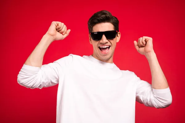 Foto di funky brunet giovane ragazzo mani pugni urlare indossare occhiali camicia bianca isolato su sfondo di colore rosso — Foto Stock