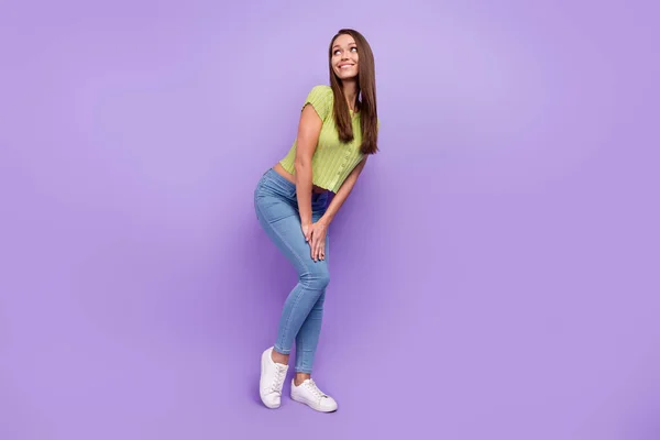 Повнометражний вигляд на тіло привабливої веселої дівчини, яка позує, вгадуючи ізольовані на фіолетовому фіолетовому кольоровому фоні — стокове фото
