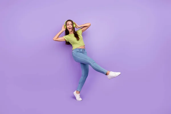 フル長いボディサイズビューのかなり屈託のない陽気な女の子リッスンロックダンス楽しみを持っています紫色の色の背景に孤立 — ストック写真