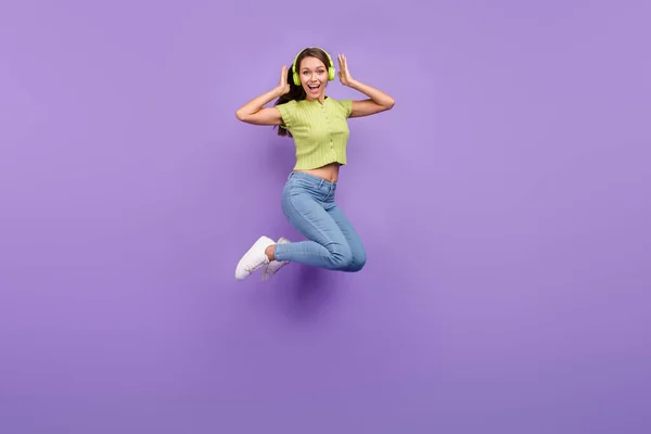 Повна довжина вигляд тіла досить весела дівчина стрибає прослуховуючи рок розважається ізольовано на фіолетовому фіолетовому кольоровому фоні — стокове фото
