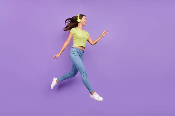Longitud completa vista del tamaño del cuerpo de la encantadora chica alegre saltando escuchando pop solo va aislado sobre violeta púrpura color de fondo — Foto de Stock