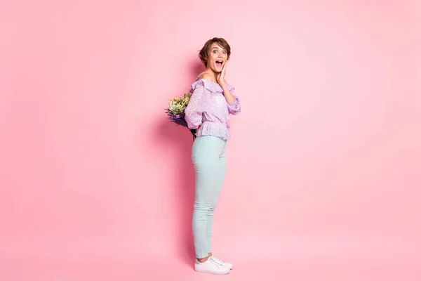 Full size profil boczny zdjęcie młody szczęśliwy szczęśliwy podekscytowany trzymać bukiet w niespodzianka odizolowany na różowym tle koloru — Zdjęcie stockowe