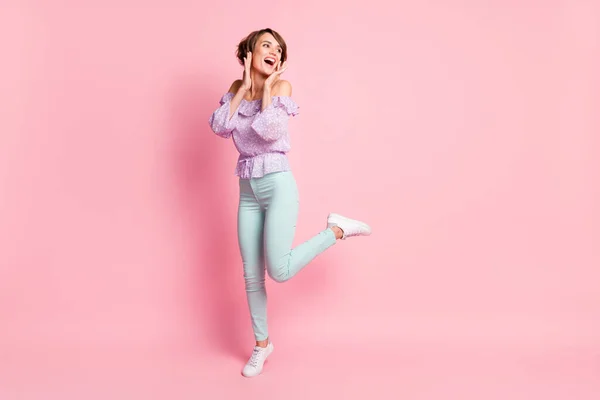 Foto de tamaño completo de joven feliz emocionada chica sonriente sorprendida bailando agarrar las mejillas aisladas en el fondo de color rosa — Foto de Stock