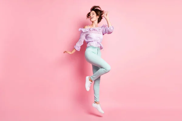 Foto de tamaño completo de joven atractiva hermosa feliz chica sonriente excitada con pelo volador saltando aislado sobre fondo de color rosa — Foto de Stock