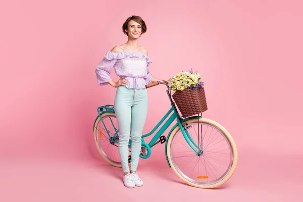 Volledige lengte foto portret van meisje staan met fiets geïsoleerd op pastel roze gekleurde achtergrond — Stockfoto