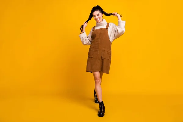 Fotografie okouzlující flirtující dáma chůze vzhled fotoaparát nosit hnědý celkový svetr boty izolované žlutá barva pozadí — Stock fotografie