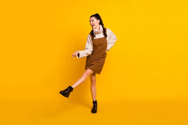 Πλήρης φωτογραφία του γλυκού χαριτωμένο νεαρή κοπέλα ντυμένος καφέ συνολικό χορό αναζητούν κενό χώρο απομονωμένο κίτρινο χρώμα φόντο — Φωτογραφία Αρχείου