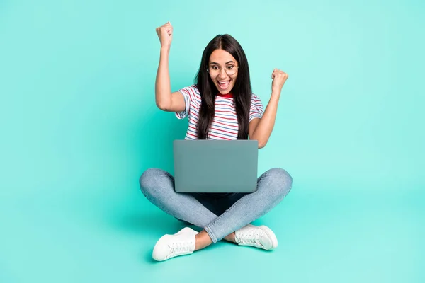 Foto ukuran penuh dari wanita hooray bagus laptop kerja duduk kacamata sepatu jeans t-shirt terisolasi di latar belakang warna teal — Stok Foto