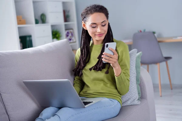 Foto de joven mujer tranquila sentarse sofá mirar teléfono portátil fin de semana en el interior de la casa casa plana — Foto de Stock