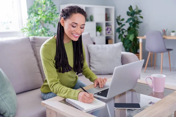 Fotografie okouzlující hezká žena oblečený svetr sedí pohovka chatování moderní gadget wring deník indoors dům domácí pokoj — Stock fotografie