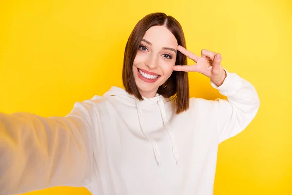 Auto-retrato de menina alegre atraente mostrando v-sinal perto do olho se divertindo isolado sobre fundo de cor amarelo brilhante — Fotografia de Stock