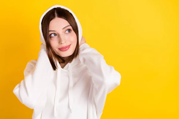 Photo of pretty cozy lady look empty space touch hood wear white sweatshirt isolated yellow color background — Stock Photo, Image